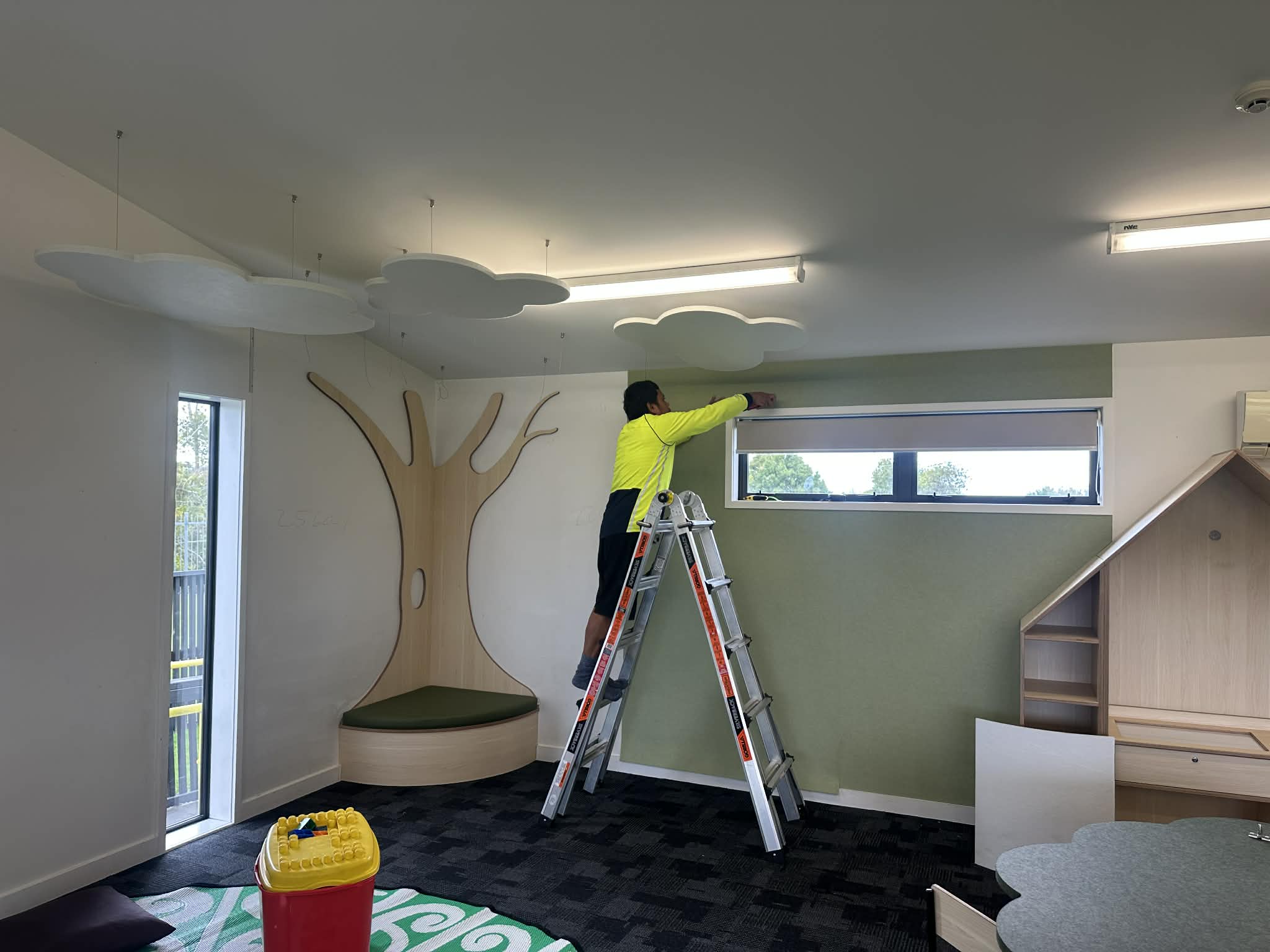 Installer fitting acoustic wall panels in a New Zealand early learning centre