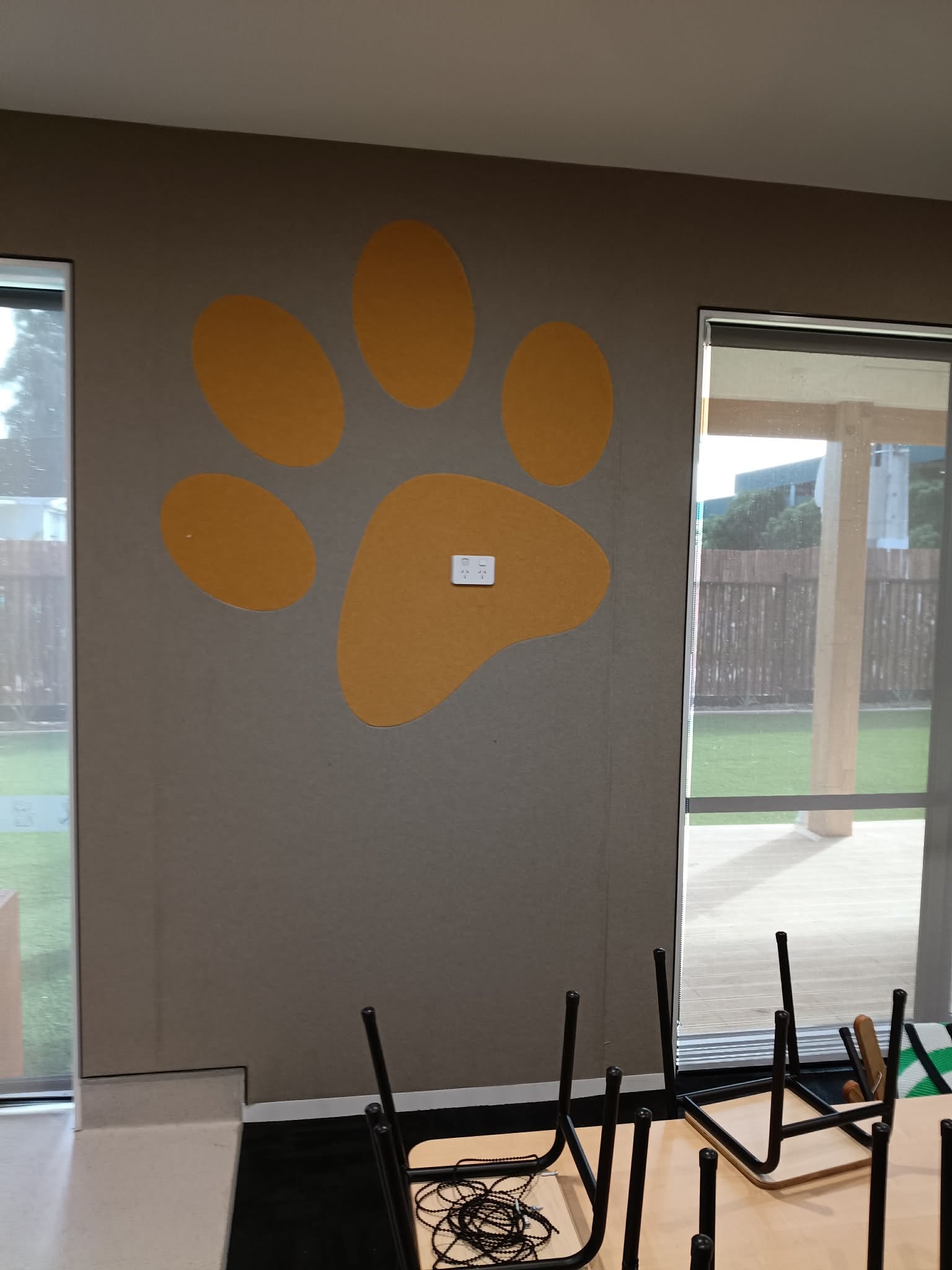Large orange paw print cut-out in an acoustic wall panel feature wall at an early learning centre
